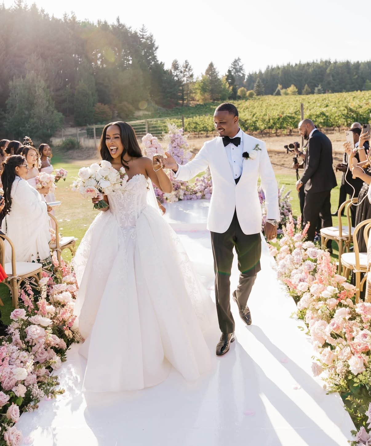 Bride and groom walking the aisle at a vineyard wedding — makeup by Sia Mia